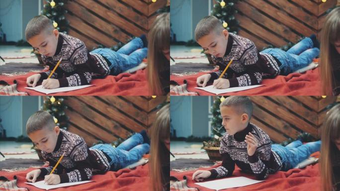 小男孩，确保他全年表现良好，正在写信给圣诞老人以获取礼物。
