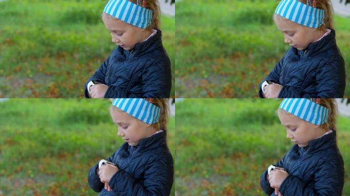 孩子在公园户外使用智能手表。在智能手机上通过vdeo通话的孩子。女学生在浏览互联网的手表上使用触摸屏