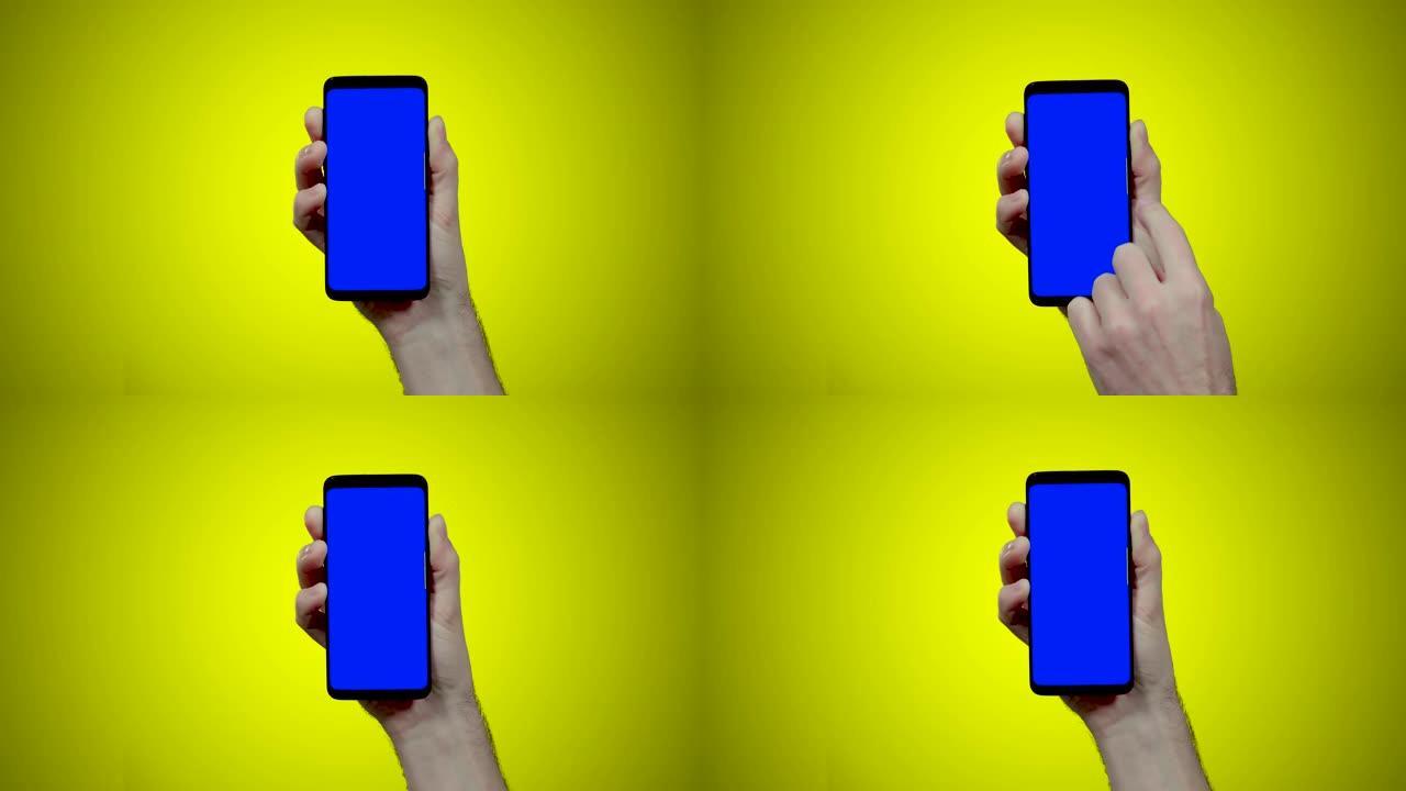 男子手持智能手机，黄色背景上有蓝色croma键，向左侧滑动两次