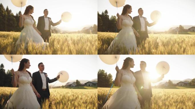 一对新婚夫妇抱着先生和女士走在麦田里。气球