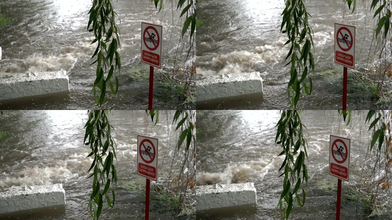 警告标志-禁止游泳-站在汹涌的水流附近。下雨时，下水道的一股脏水排入河中。背景模糊。概念。4K