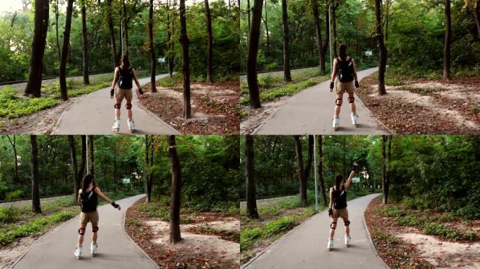年轻快乐的女性在夏季公园享受轮滑。年轻迷人的女性正在公园里溜旱冰。