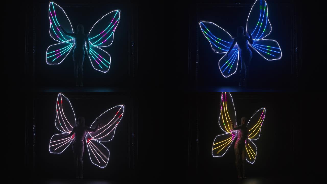 黑色背景上可以看到一个有着发光蝴蝶翅膀的女人的剪影。戏剧声乐表演。慢动作