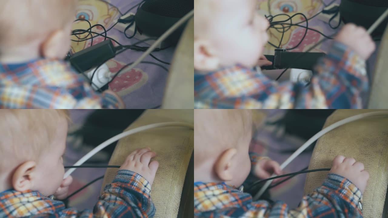 无忧无虑的婴儿玩电子设备和电缆