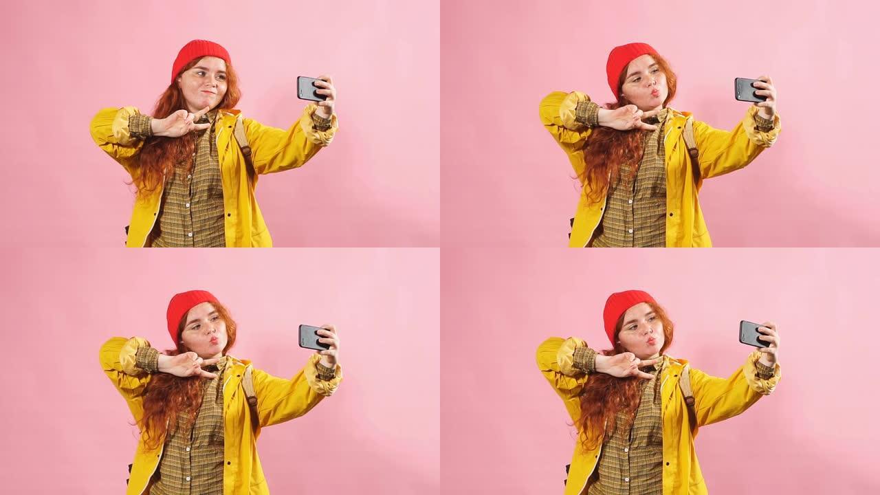 年轻迷人的红发女孩在电话里给自己拍照