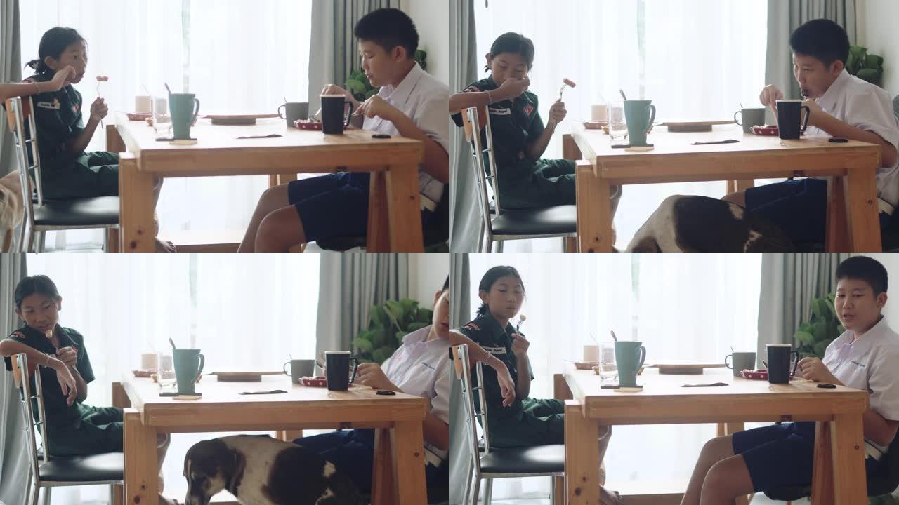 穿着制服的亚洲女学生上学前和哥哥在家吃早餐，生活方式理念。