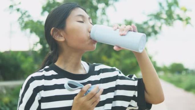亚洲女孩户外喝一瓶水，生活理念。