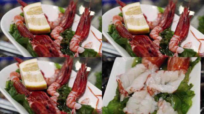 新鲜美味的皇家大虾躺在白色盘子里，柠檬和香草。鱼市场柜台上的异国情调的地中海虾，餐厅的豪华海鲜