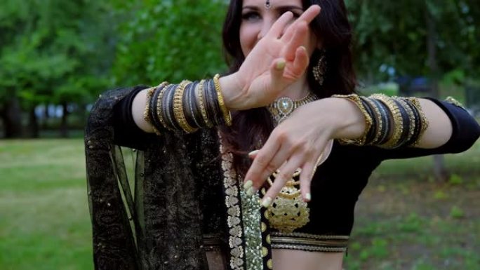 穿着印度民族服装，珠宝和传统化妆的女模特肖像。穿着印度衣服的女人跳肚皮舞。年轻漂亮的女人穿着民族服装