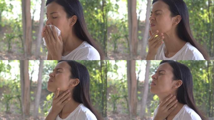 年轻的亚洲妇女触摸疼痛的脖子，喉咙痛的流感，感冒和感染