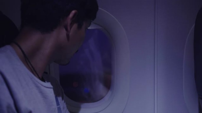 亚洲游客打开飞机上的窗户