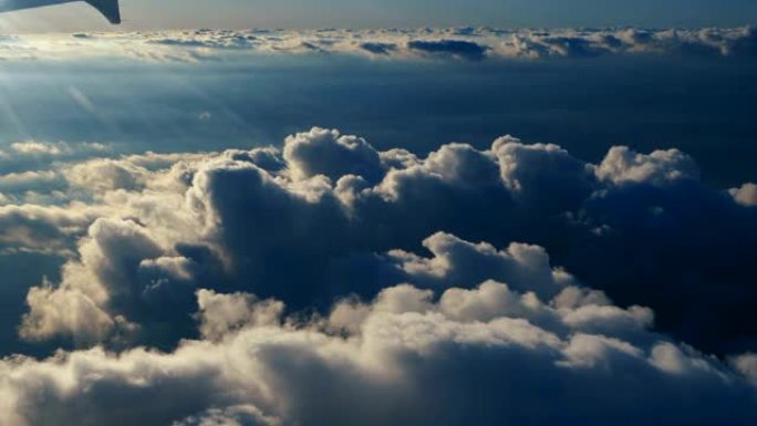 从蓝天的飞机窗户俯瞰云层。从飞机窗口可以看到蓝天白云。乘飞机旅行。