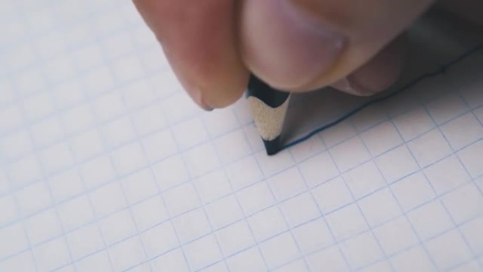 男子在方格纸上用深蓝色铅笔画线