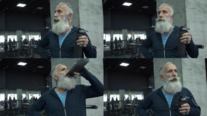 大胡子的老人试图在健身房呼吸和喝水