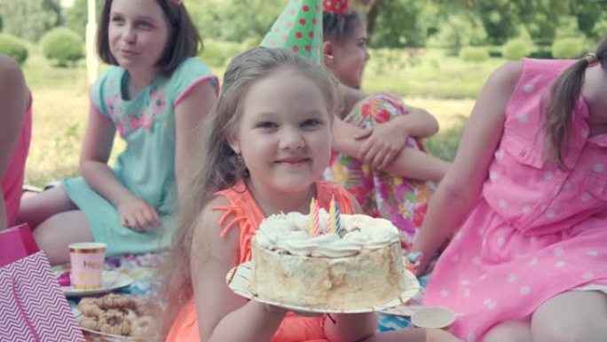 女孩看着相机，手里拿着蛋糕。快乐的孩子。