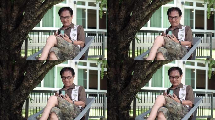 坐在家里的长凳上做视频聊天的高级男子。