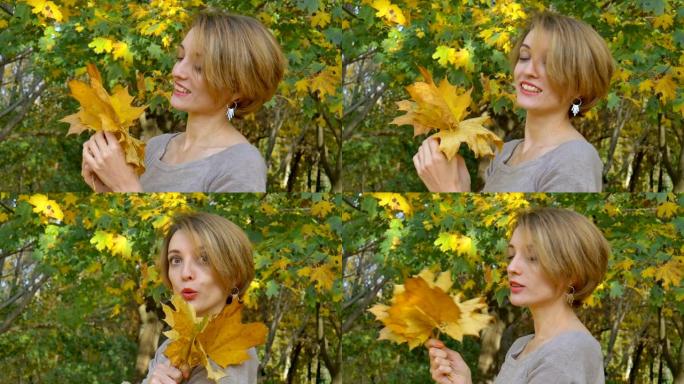 富有情感魅力的年轻女子，金发短发，biege连衣裙，头顶上捧着一束秋叶，在户外美丽的公园摆姿势