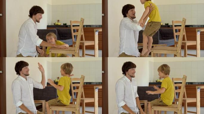 父亲和儿子用小零件组装木制家具。组装好椅子后，男人把儿子放在椅子上，给他五分。