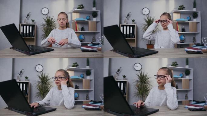 自信漂亮的现代少女的特写镜头，在笔记本电脑开始工作之前戴上眼镜