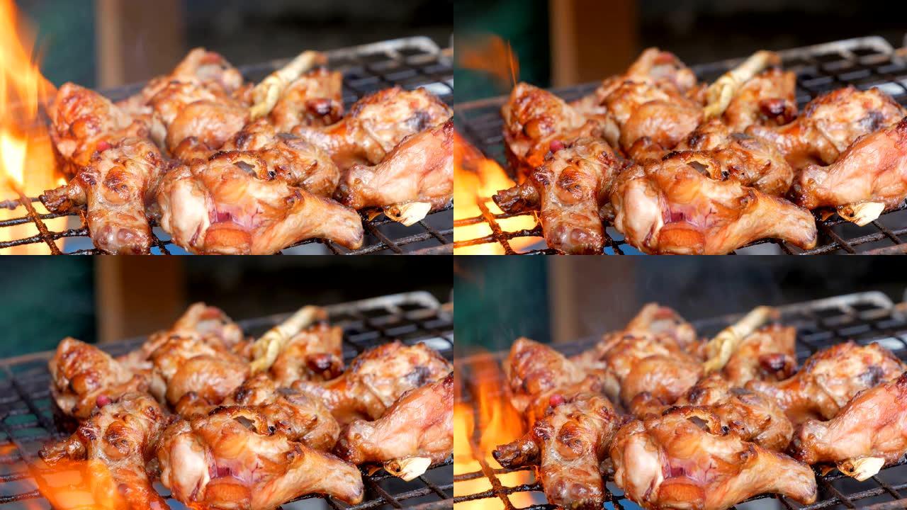 烤鸡放在炭藤上的黑色烤架上，着火。选择聚焦浅景深。