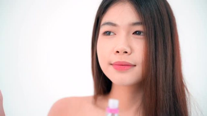 年轻的亚洲女性在镜子前化妆