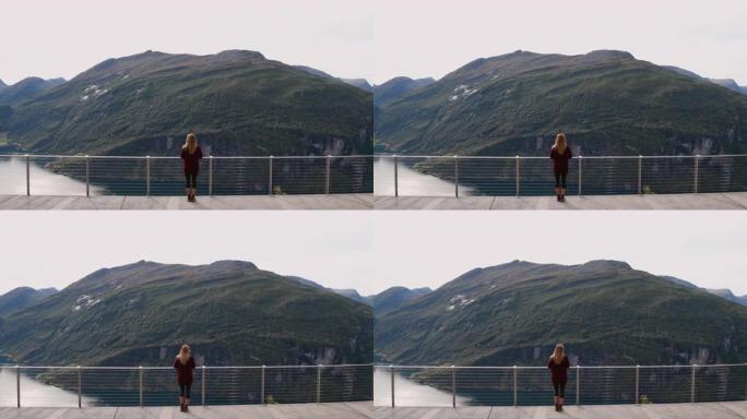 一个女人看着山脉和峡湾的视频。