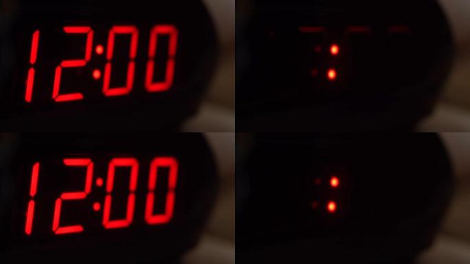 黑色数字时钟屏幕的特写显示12.00。黑色背景上闪烁红色数字。现代定时器系统和霓虹灯、电动报警装置