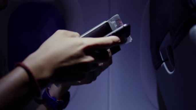 CU男子的手在飞机上手持登机牌，护照和智能手机