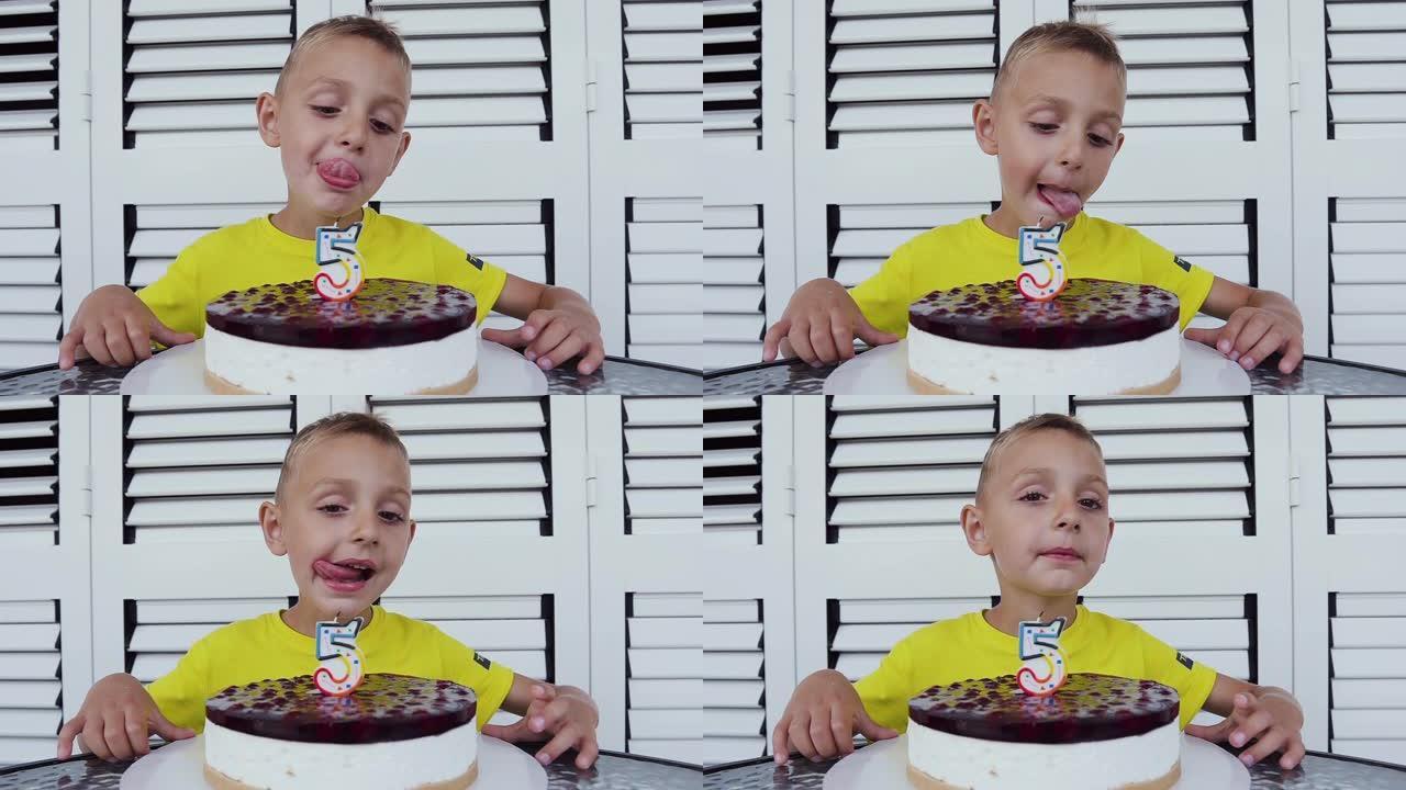 这个可爱的男孩正在庆祝他的5岁生日，坐在餐桌旁，端着一个美味的蛋糕，孤立在白色背景上。一个小男孩生日
