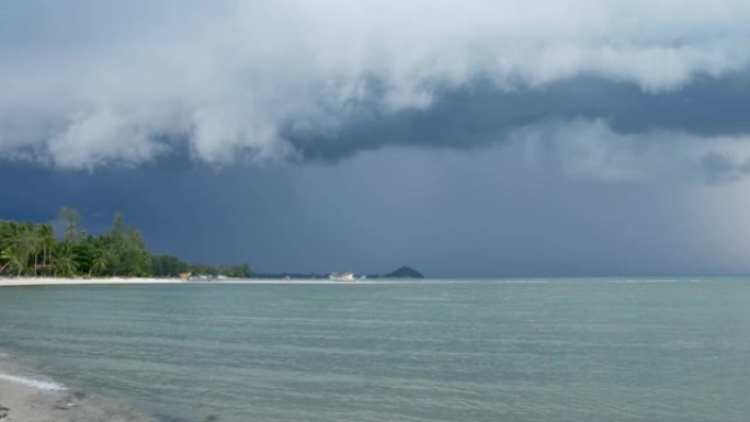 泰国湿雨季，苏梅岛沙质海岸挥舞着蓝色的大海。异国热带海洋海滩上的飓风和风暴警告。快速的风和不祥的云。