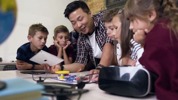 一组六名学童，老师在课堂上在电子构造器中发射风扇时使用数字平板电脑