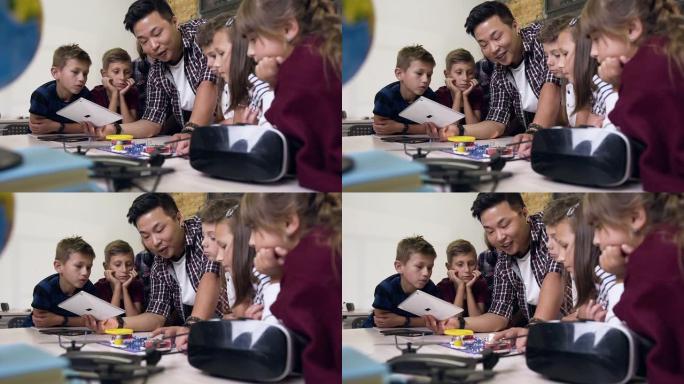 一组六名学童，老师在课堂上在电子构造器中发射风扇时使用数字平板电脑