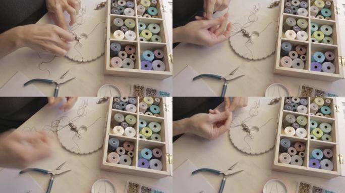 生活方式概念，在家工作以重塑您的生活: 女人的手的特写细节制作了带有彩色线轴的macrame打结的珠