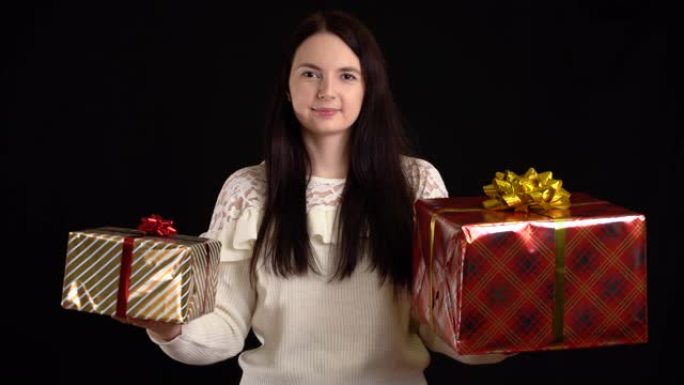 黑色背景上有礼品盒的年轻女子。带有白色丝带的礼品盒，用于新年快乐，圣诞快乐，情人节，生日