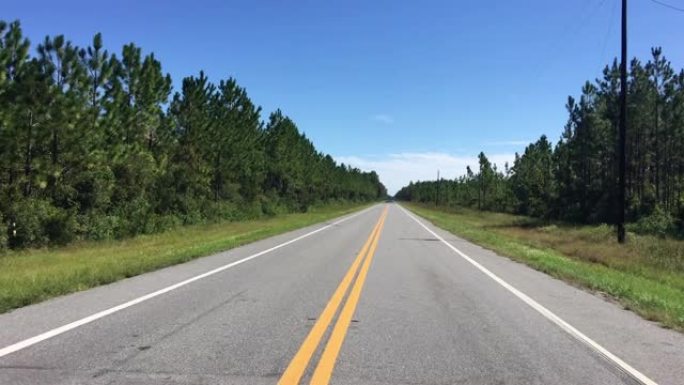 驾驶员的观点是在森林中空旷的铺砌道路上穿越火车轨道