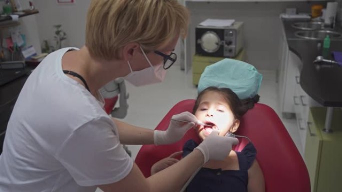 勇敢的5岁女孩在每月检查时坐在牙医的椅子上