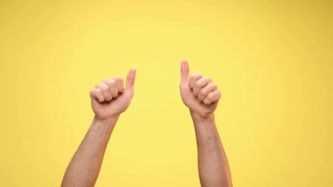 两只手臂指向相机，竖起大拇指，在黄色背景上庆祝成功
