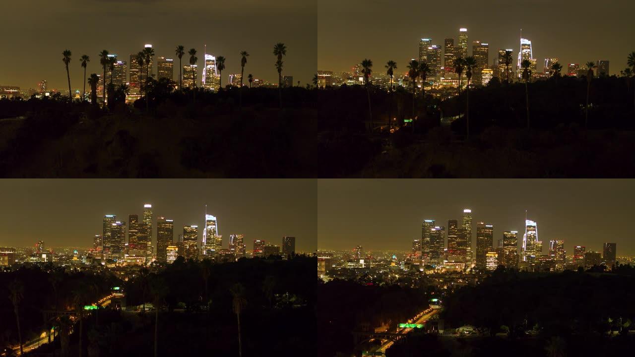 夜间在洛杉矶市中心与棕榈树的空中拍摄