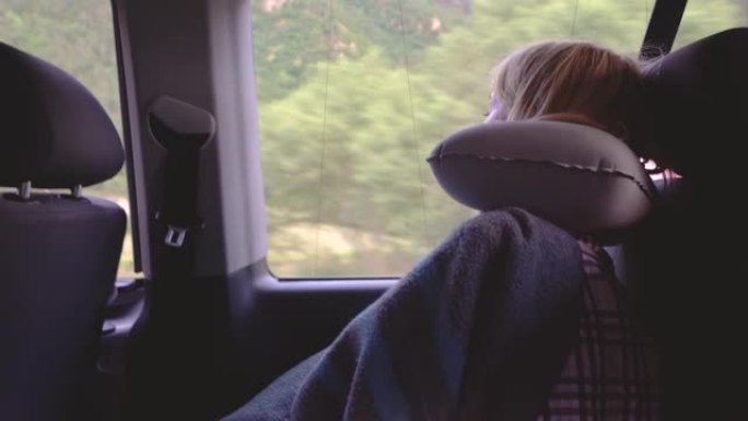 镜头年轻女子坐公共汽车睡觉。她在头下放了一个充气枕头。