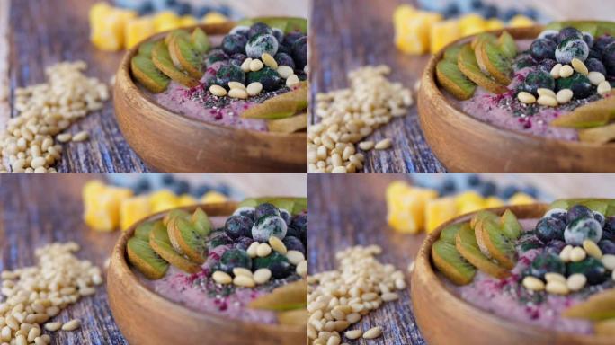 冰沙碗配新鲜和冷冻的蓝莓、猕猴桃、香蕉、龙果粉和松子