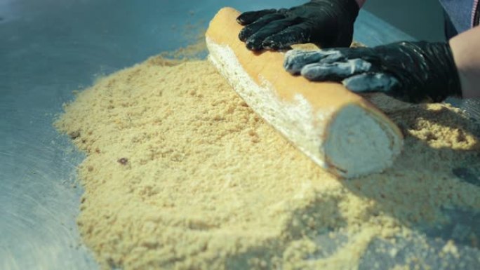 女面包师正在用切碎的坚果装饰奶油海绵蛋糕。