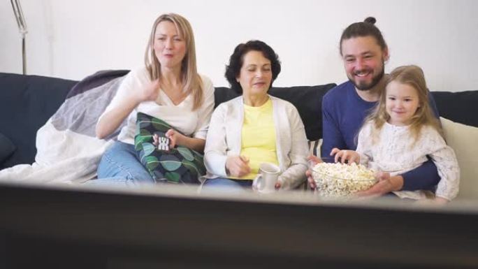幸福的一家人坐在沙发上，一起看爆米花电视