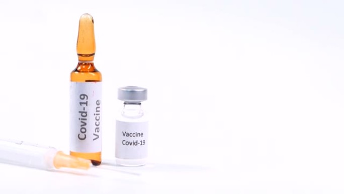 白色背景上的冠状病毒疫苗和注射器的特写