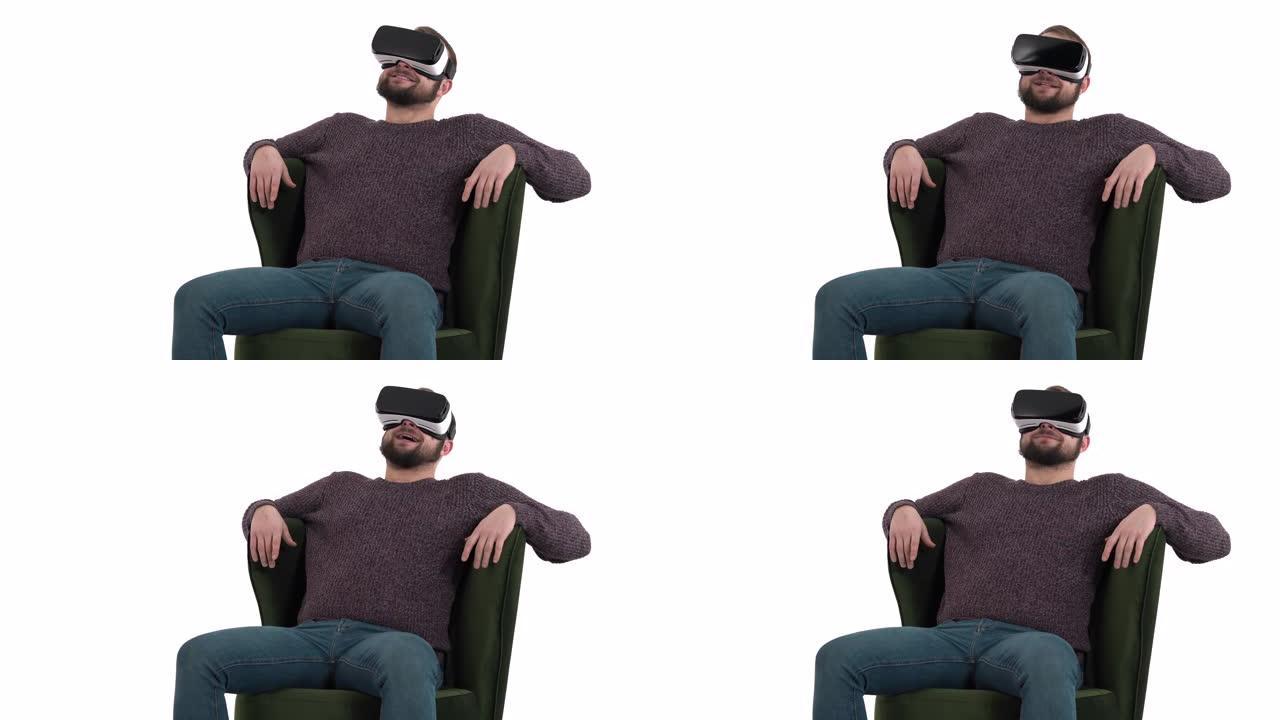 技术、虚拟现实、娱乐和人的概念 -- 微笑的男人带着vr耳机或3d眼镜坐在绿色扶手椅上