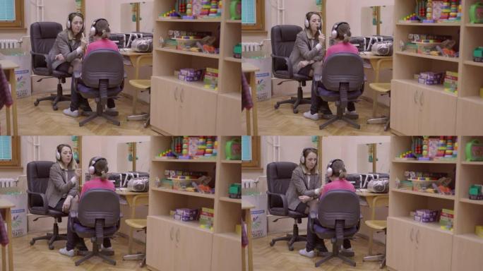 语音治疗师在音频实验室与残疾女孩一起工作