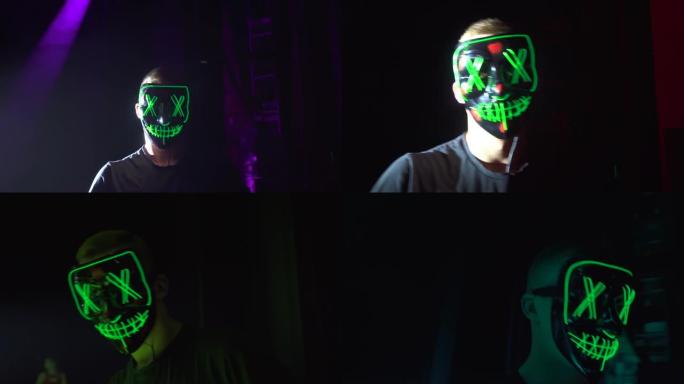 一个人戴着面具在舞台上表演。它发出绿色。Ananimus。
