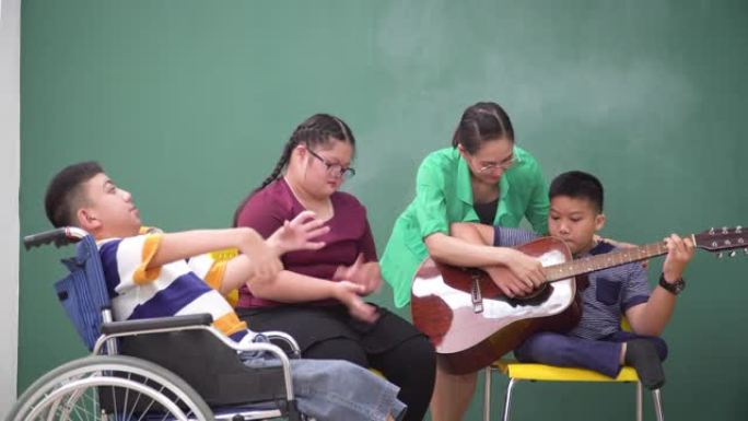 一个坐在轮椅上的残疾男孩和一个患有唐氏综合症的女孩坐在一起，在学校里上音乐课和治疗。亚洲老师教男孩如