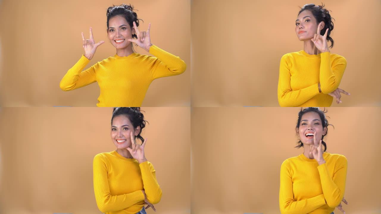 4k中拍肖像快乐年轻美丽的亚洲女子女孩脸和身体穿着黄色长袖上衣是微笑孤立的背景。人的脸和身体具有快乐