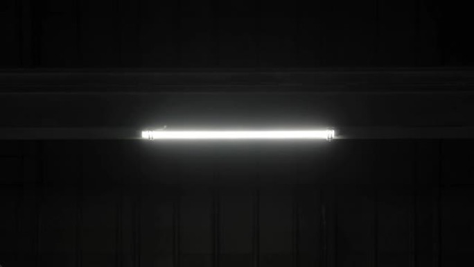金属光束隔板上的发光二极管灯在没有窗户的工厂、机库、车间部门的黑暗房间闪烁并打开。工业制造区停电、电