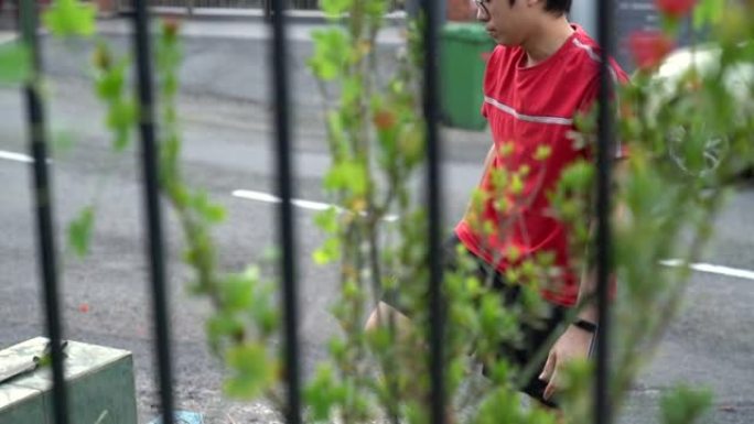 勤劳的亚洲华人成年男性正在清理杂草丛生的花园